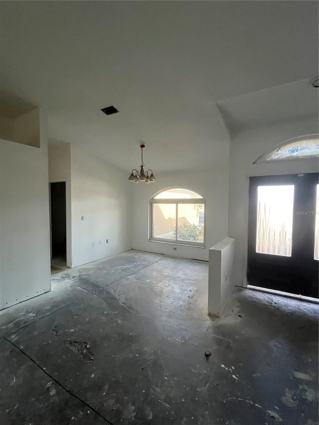 unfurnished living room featuring a chandelier