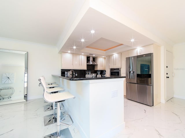 kitchen with white cabinetry, wall chimney range hood, stainless steel appliances, and kitchen peninsula