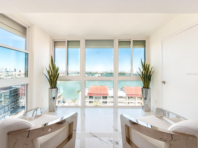 sunroom featuring a water view