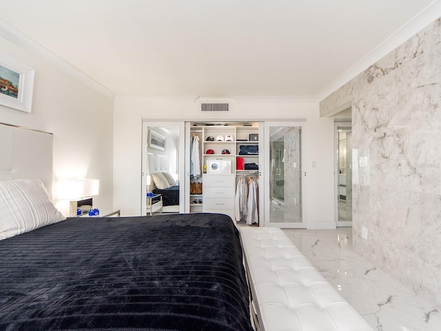 bedroom with crown molding and a closet