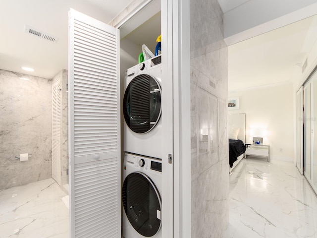 clothes washing area with stacked washer and dryer