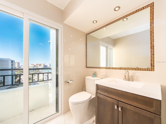 bathroom with tile walls, vanity, and toilet