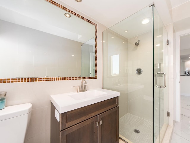 bathroom featuring vanity, tile walls, toilet, and walk in shower