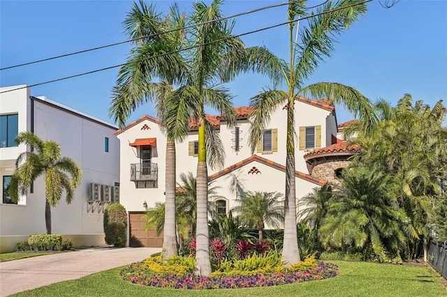 exterior space featuring driveway, a front yard, a tiled roof, and stucco siding