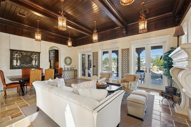 living area with stone tile floors, visible vents, arched walkways, wood ceiling, and french doors