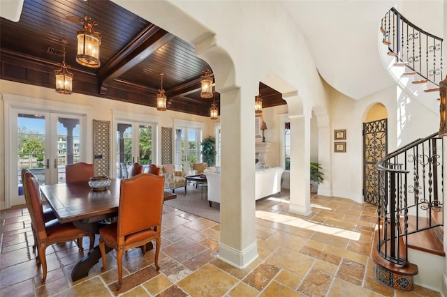 dining space featuring french doors, stone tile floors, stairway, wooden ceiling, and plenty of natural light