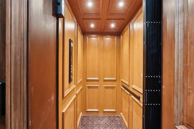 details featuring a decorative wall, recessed lighting, coffered ceiling, ornamental molding, and elevator