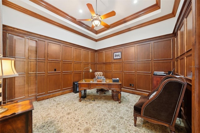 home office with crown molding, a raised ceiling, a decorative wall, and ceiling fan