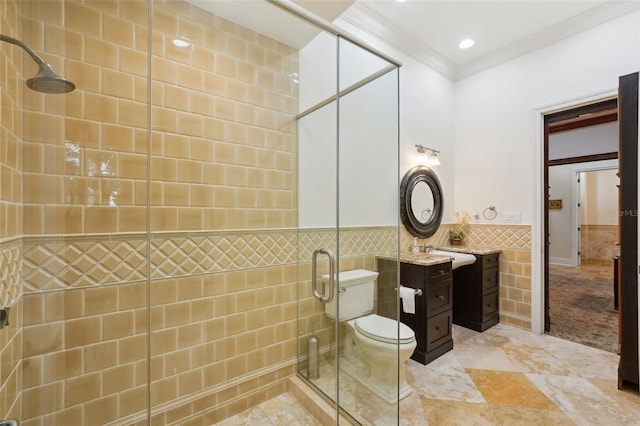 bathroom with tiled shower, a wainscoted wall, crown molding, vanity, and tile walls