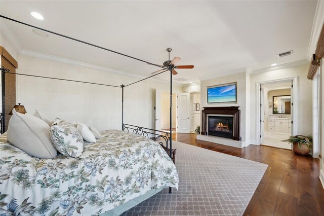 bedroom featuring recessed lighting, dark wood-style flooring, visible vents, a lit fireplace, and crown molding