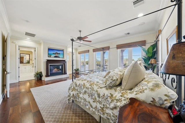 bedroom featuring a glass covered fireplace, visible vents, and crown molding