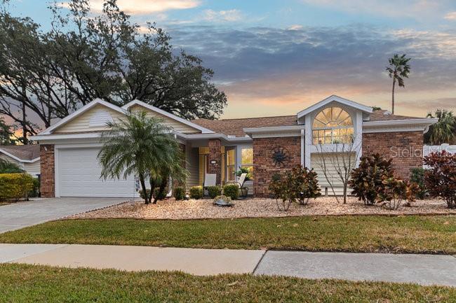 ranch-style house with a garage and a lawn