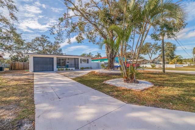 single story home featuring a garage and a front lawn