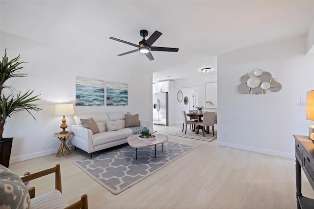 living room with ceiling fan and light wood-type flooring