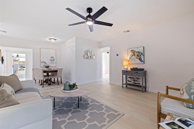 living room featuring ceiling fan and light hardwood / wood-style flooring