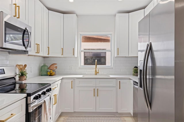 kitchen with white cabinetry, sink, backsplash, and stainless steel appliances