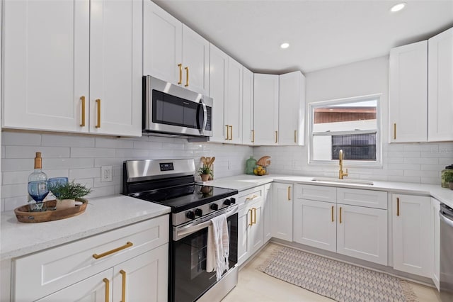 kitchen featuring tasteful backsplash, stainless steel appliances, sink, and white cabinets