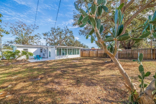 back of property with a patio area, a sunroom, and a lawn