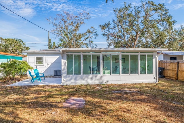 rear view of house featuring central AC, a yard, a sunroom, and a patio