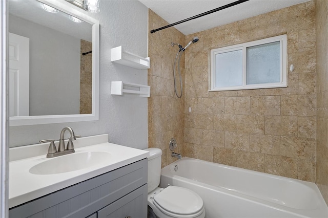 full bathroom with vanity, a textured ceiling, toilet, and tiled shower / bath