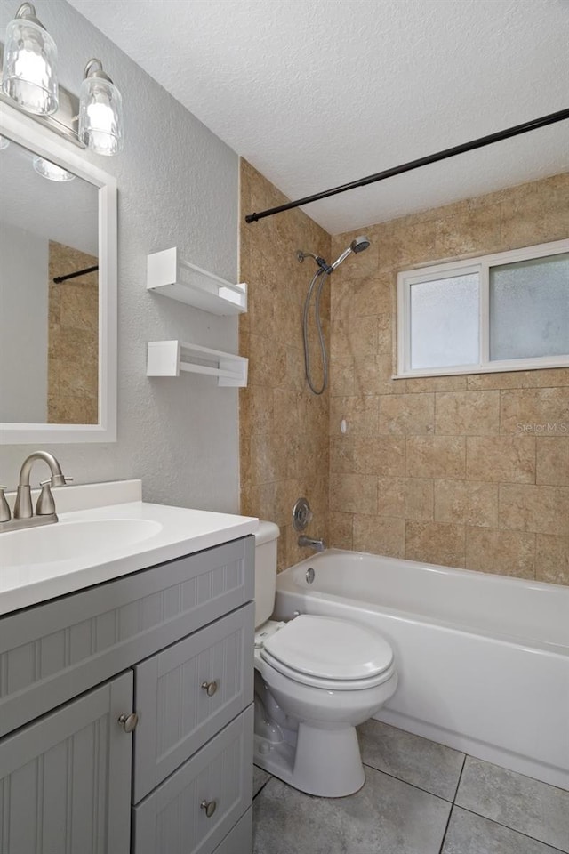 full bathroom featuring tiled shower / bath combo, vanity, toilet, tile patterned floors, and a textured ceiling