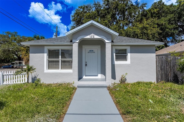 bungalow-style house featuring a front lawn