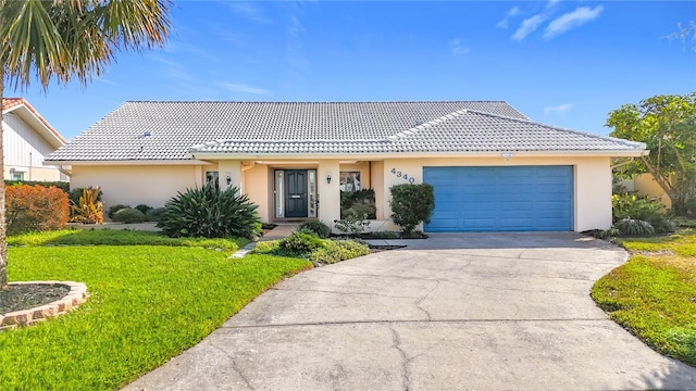 ranch-style house with a garage and a front lawn