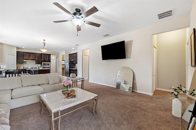 living room with ceiling fan and carpet flooring