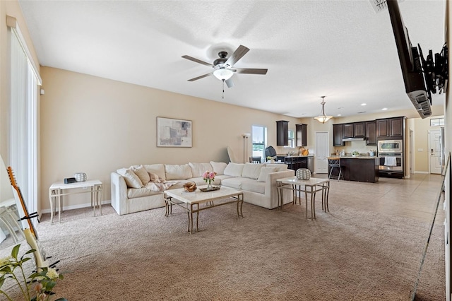 living room with light carpet, a textured ceiling, and ceiling fan