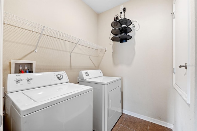 laundry room featuring washer and dryer and dark tile patterned floors