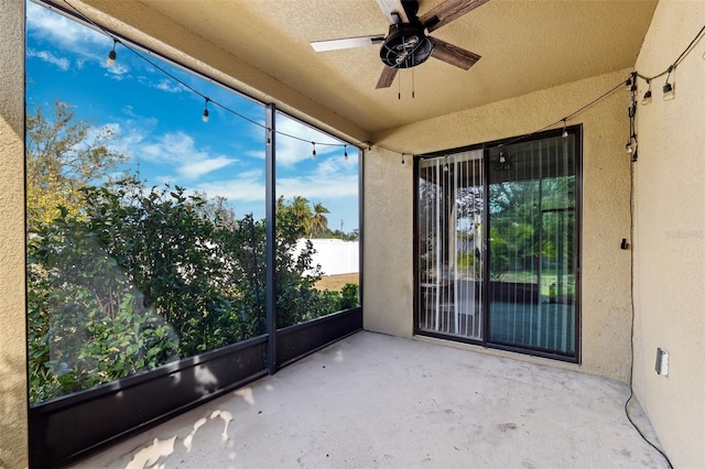 unfurnished sunroom with ceiling fan