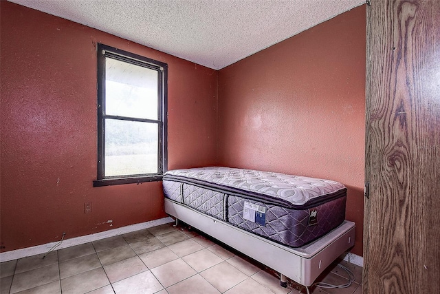 tiled bedroom featuring a textured ceiling