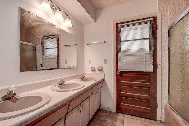 bathroom with tile patterned floors, shower / bath combination with glass door, and vanity