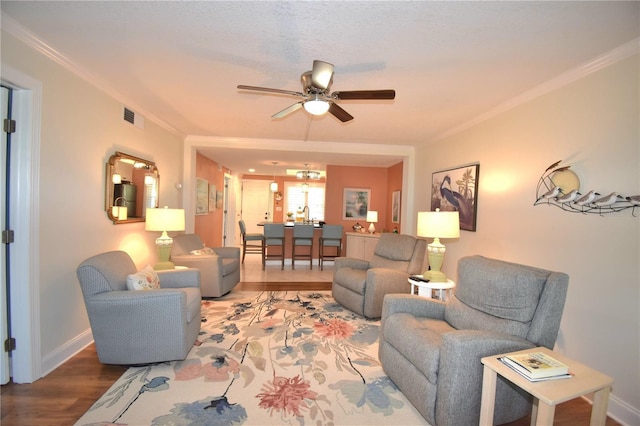 living room featuring crown molding, ceiling fan, wood-type flooring, and a textured ceiling