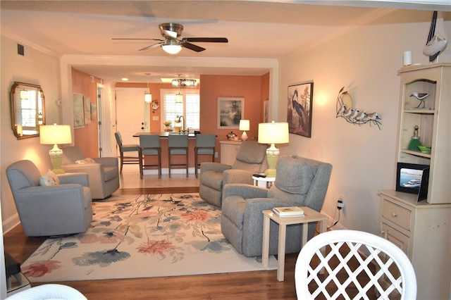 living room featuring crown molding, ceiling fan, and wood-type flooring