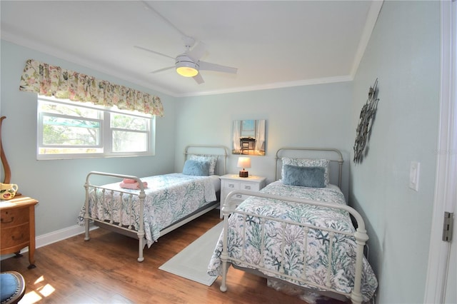 bedroom featuring hardwood / wood-style floors, crown molding, and ceiling fan