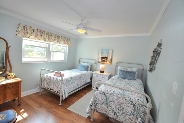 bedroom featuring wood-type flooring, ornamental molding, and ceiling fan