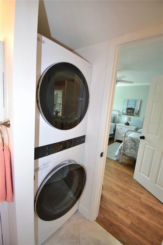 washroom featuring light hardwood / wood-style flooring and stacked washing maching and dryer