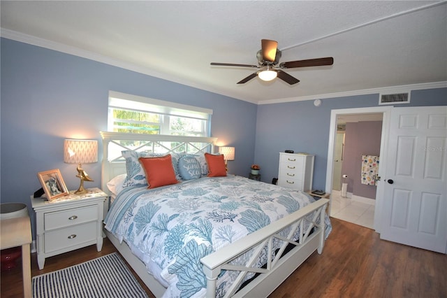 bedroom with crown molding, dark wood-type flooring, and ceiling fan