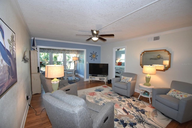 living room featuring hardwood / wood-style flooring, ornamental molding, ceiling fan, and a textured ceiling