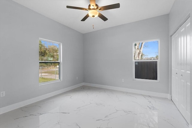 unfurnished room with ceiling fan and a healthy amount of sunlight