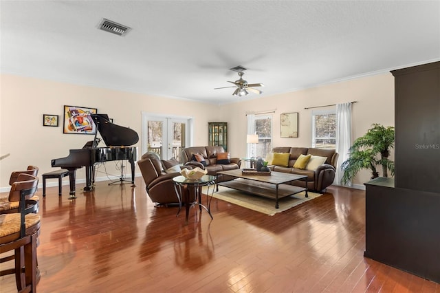 living room featuring crown molding, hardwood / wood-style floors, ceiling fan, and french doors