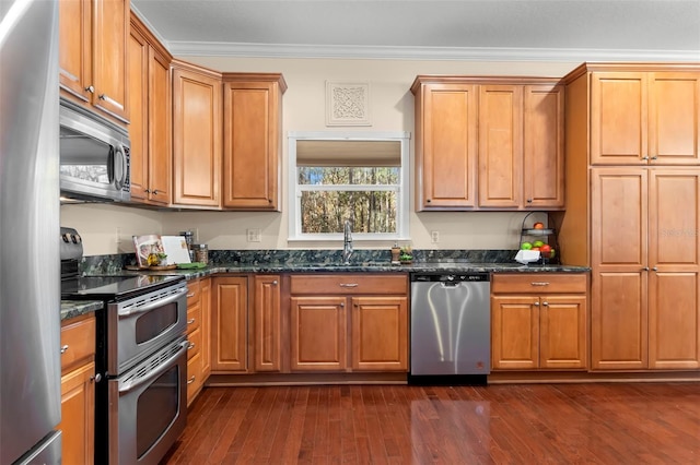 kitchen featuring stainless steel appliances, dark hardwood / wood-style flooring, sink, and dark stone countertops