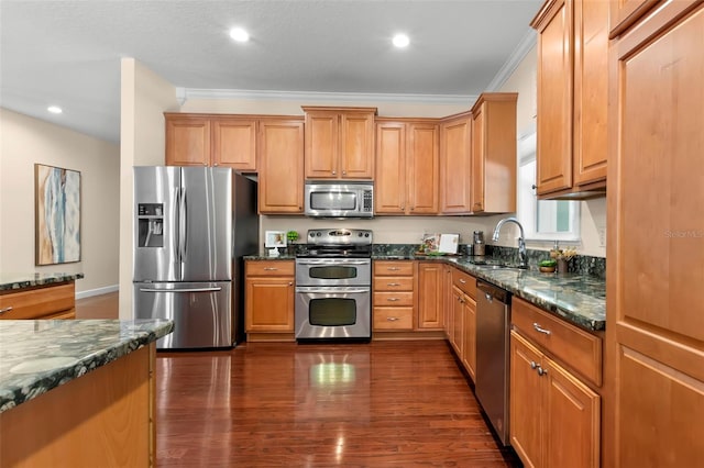 kitchen featuring sink, crown molding, dark stone counters, dark hardwood / wood-style flooring, and stainless steel appliances