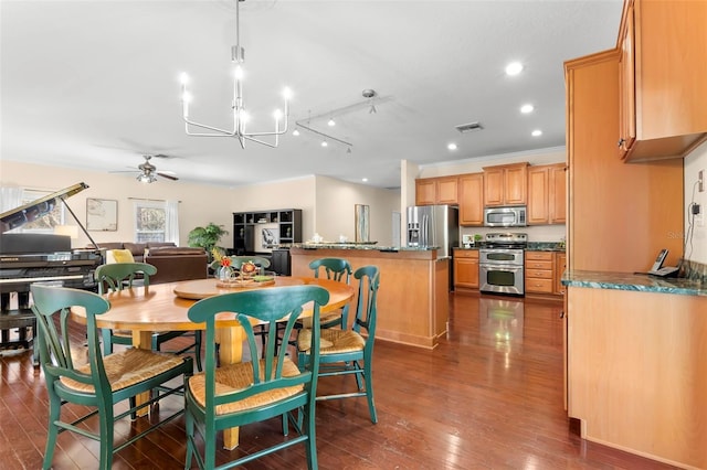 dining area featuring ceiling fan with notable chandelier and dark hardwood / wood-style flooring