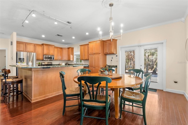 kitchen with a breakfast bar, stainless steel appliances, ornamental molding, a kitchen island, and dark stone counters