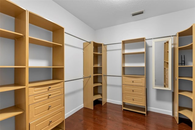 spacious closet with dark hardwood / wood-style flooring