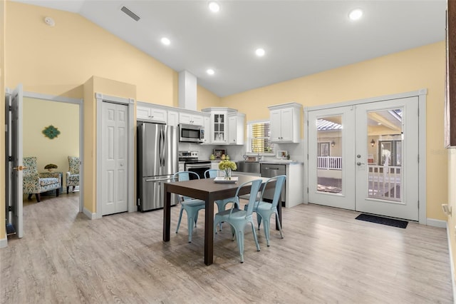 kitchen with white cabinetry, appliances with stainless steel finishes, french doors, and light hardwood / wood-style flooring