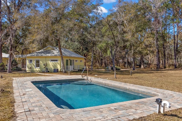 view of pool with a lawn and a patio