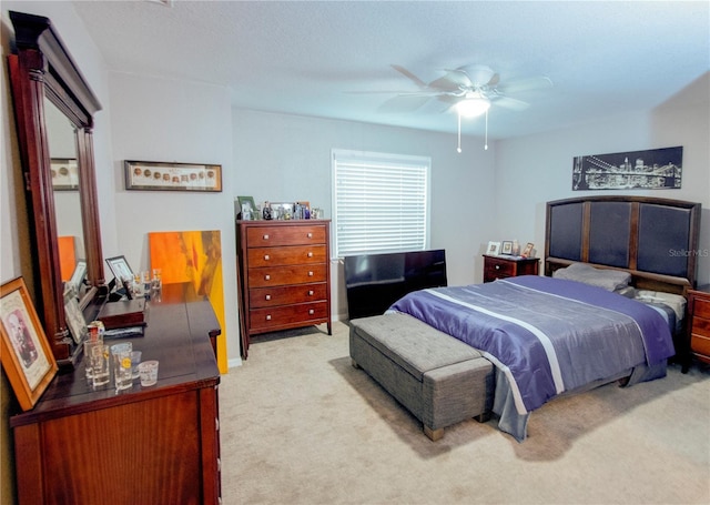 bedroom featuring light carpet and a ceiling fan